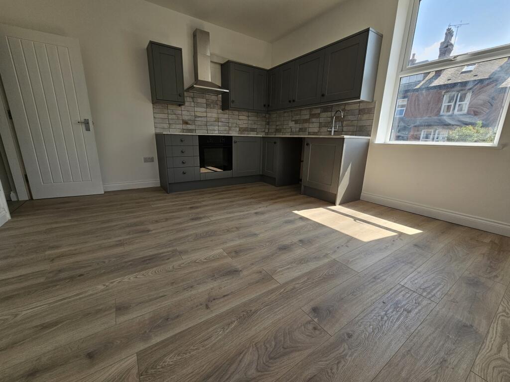 Bright open-plan kitchen with modern grey fitte...