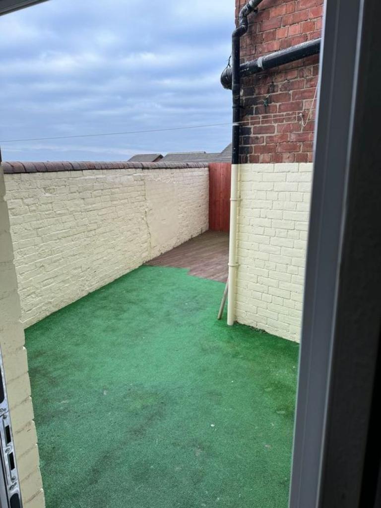 A private outdoor garden area with clean artifi...