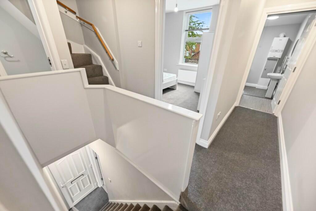 Bright and clean hallway featuring neutral deco...
