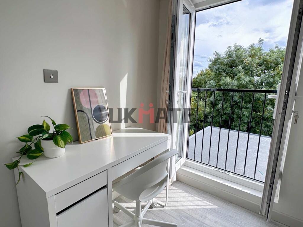 A bright and airy bedroom featuring a sleek whi...
