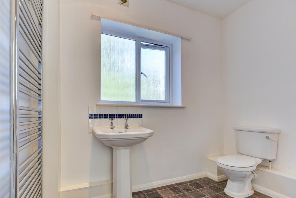 Bright and tidy bathroom featuring a modern whi...