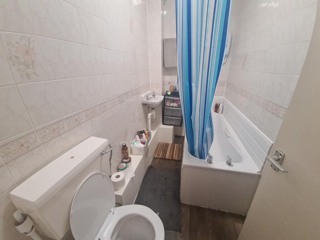 A neat and functional bathroom featuring a whit...