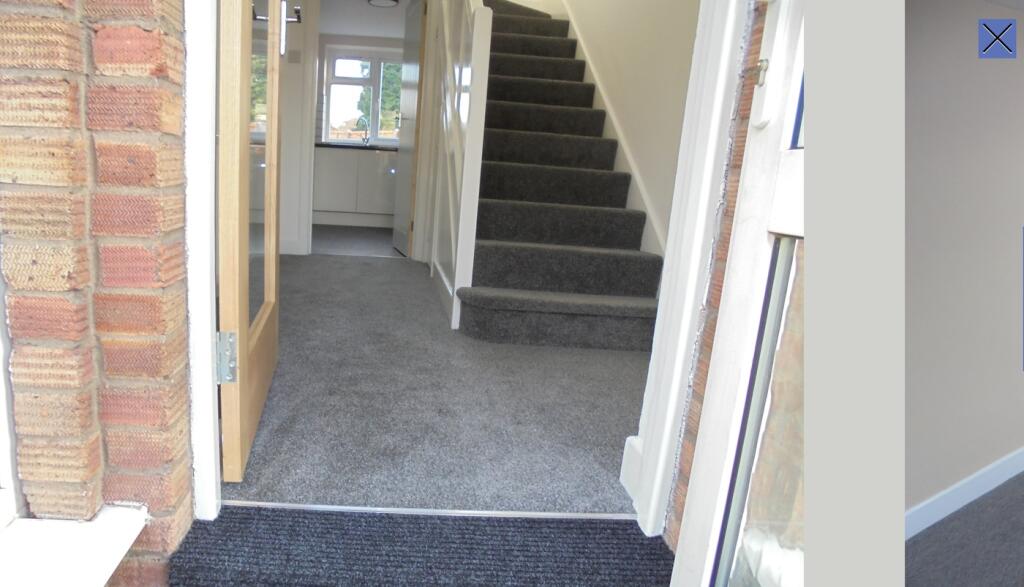 A clean and inviting hallway leading to a well-...