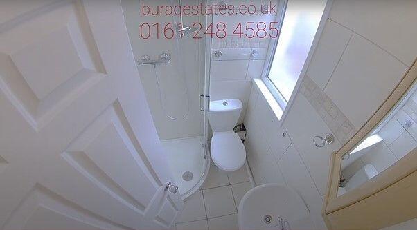 Compact, clean bathroom with a modern shower en...