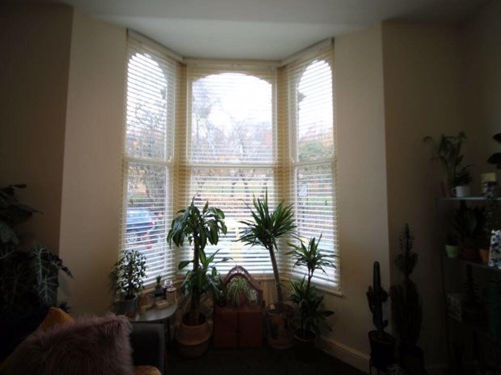 A bright and welcoming living room featuring la...