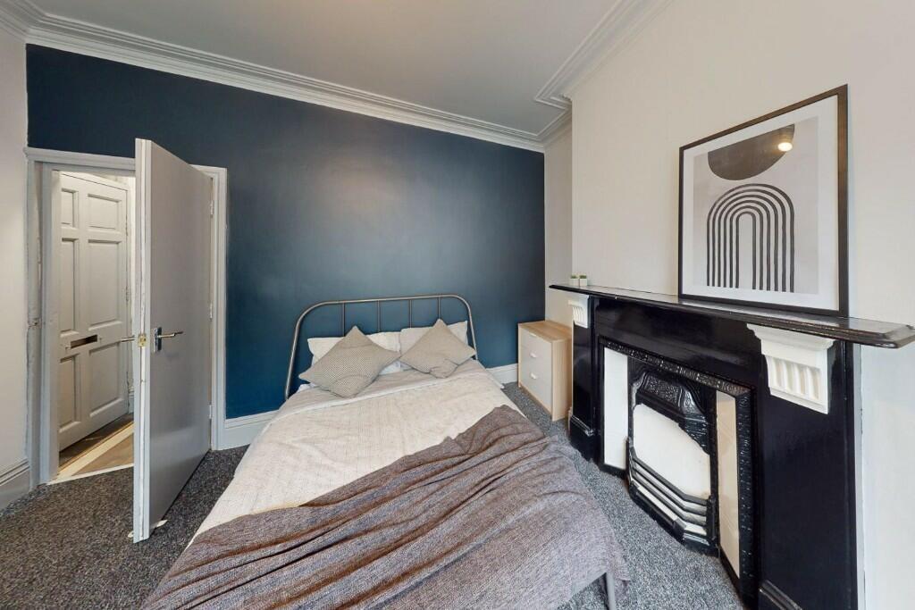 A cozy double bedroom featuring a stylish dark ...