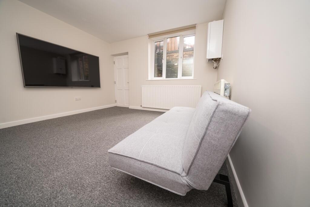 A clean and modern living room featuring a wall...
