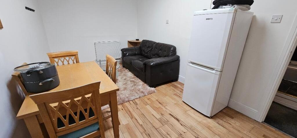 A cozy living room featuring a black leather so...