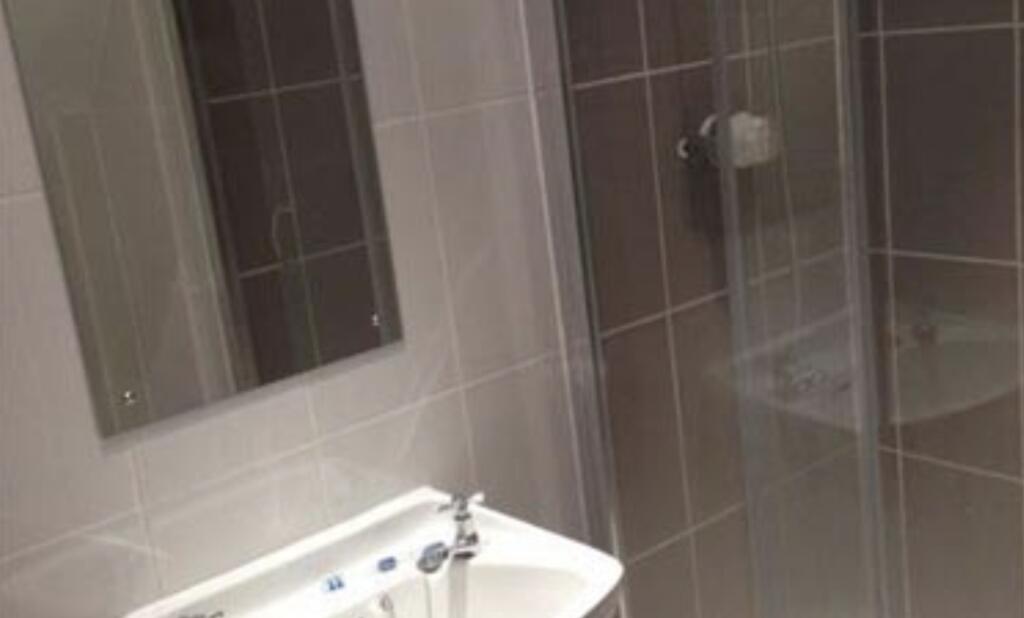 Modern bathroom with a white basin, mirrored ca...