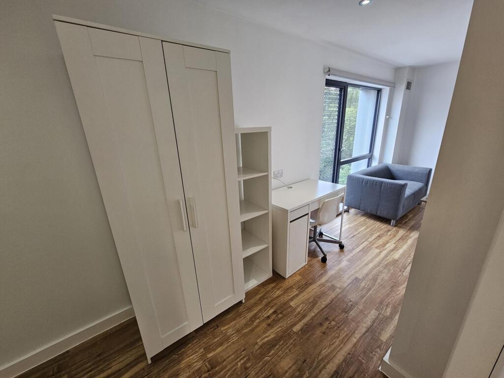 Bright single bedroom featuring wooden flooring...