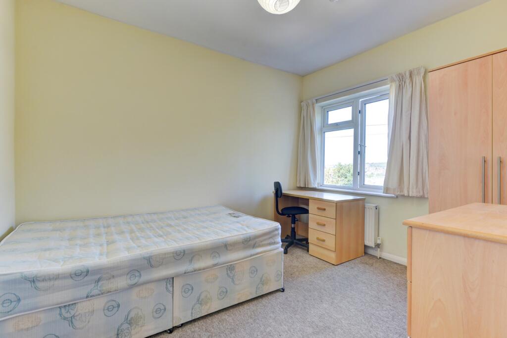 Bright and simple bedroom featuring a comfortab...