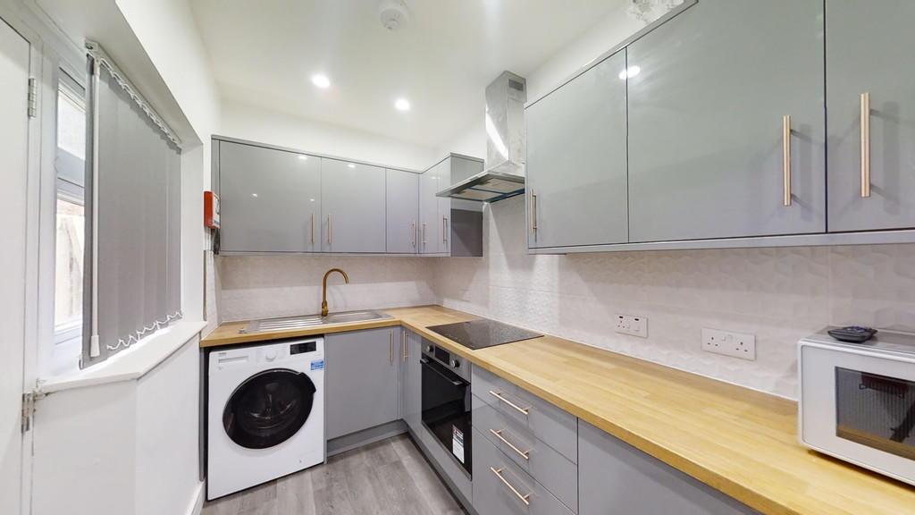 Modern kitchen with sleek grey cabinetry, woode...
