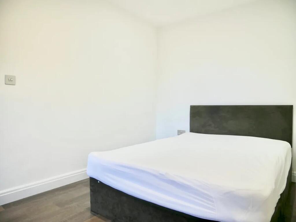 A neat double bedroom featuring a modern uphols...