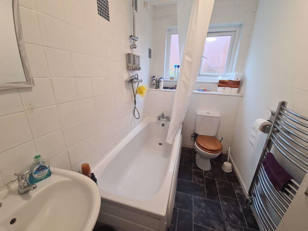 Bright, clean bathroom with a bathtub, shower, ...