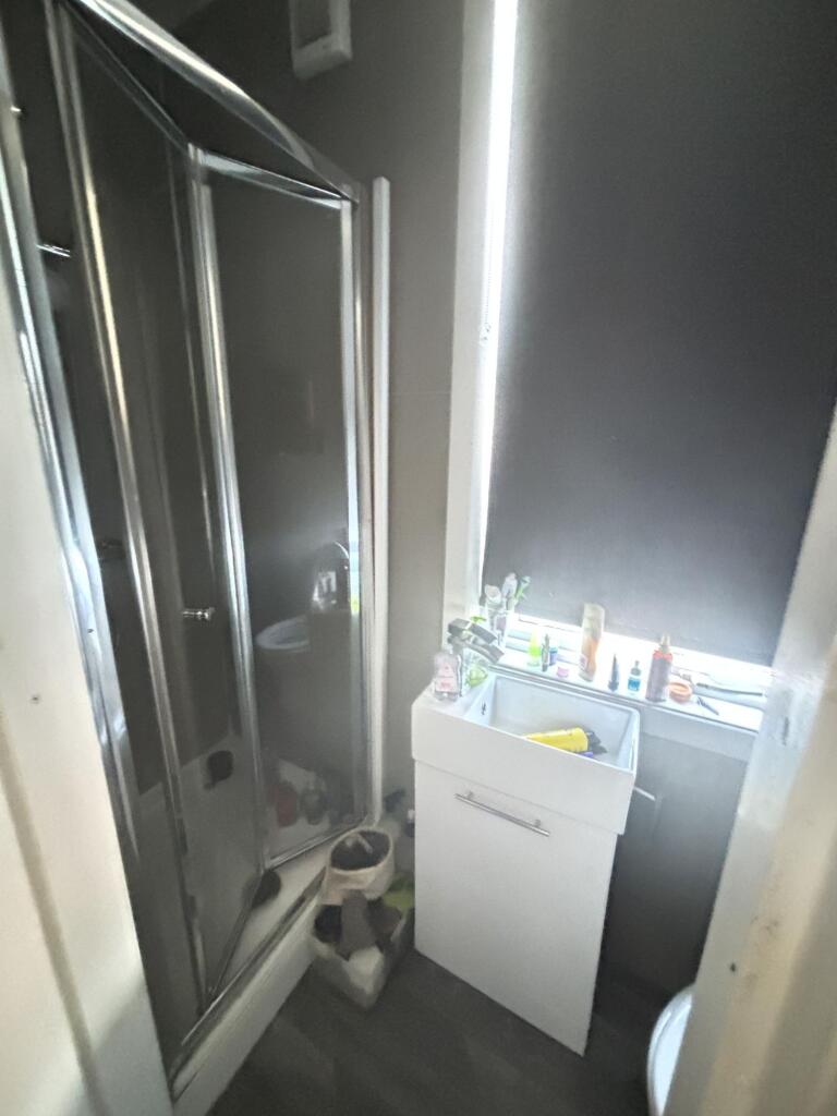 A functional bathroom with a shower unit and a ...