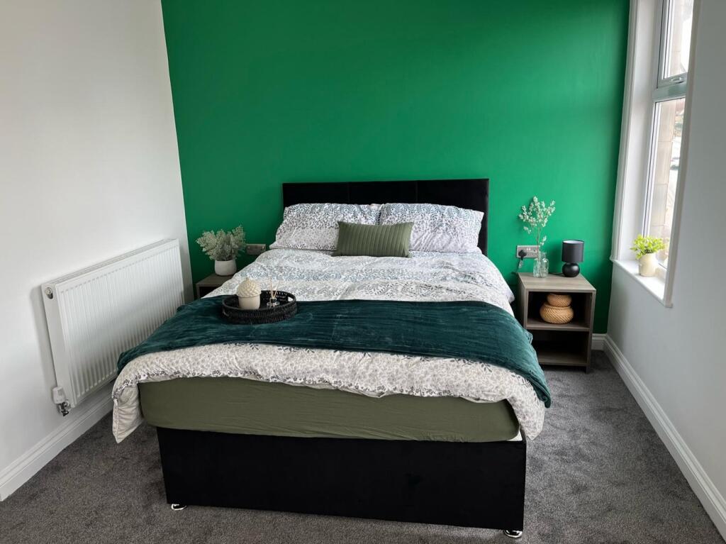 This inviting double bedroom features a cozy la...