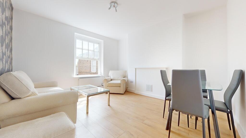 Bright and airy living room featuring light woo...