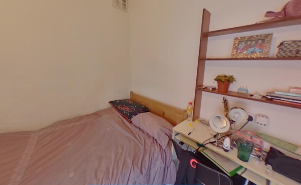 Cozy single bedroom featuring a comfortable bed...