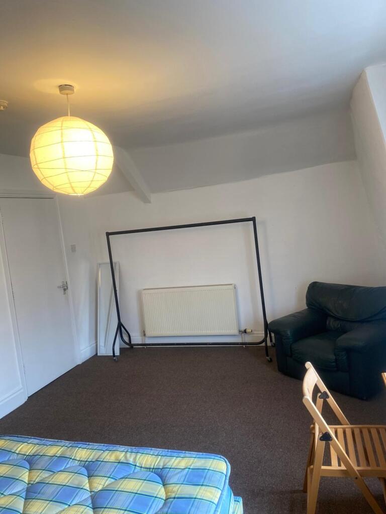 A clean and tidy single bedroom with a comfy ar...