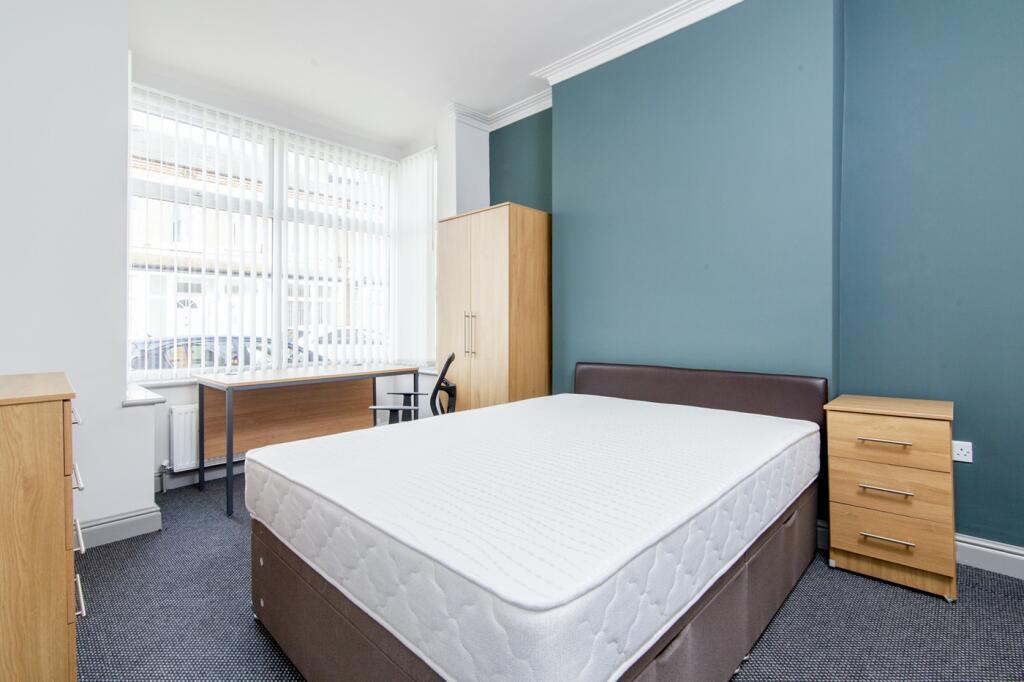 A spacious and bright double bedroom featuring ...