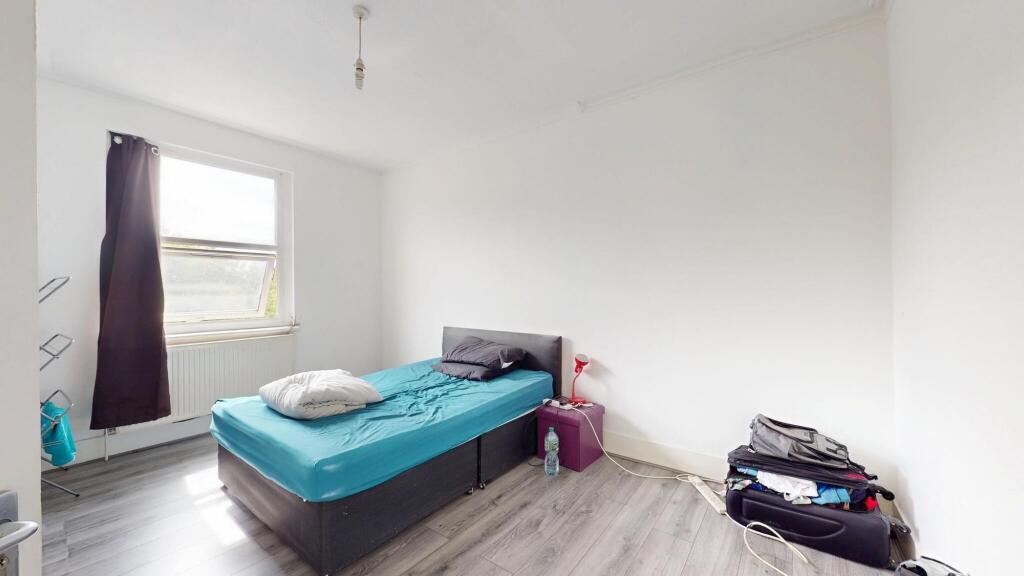 A modest single bedroom featuring a single bed ...