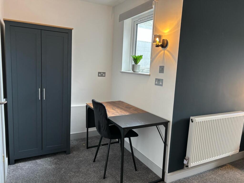 This cozy double bedroom features a well-design...