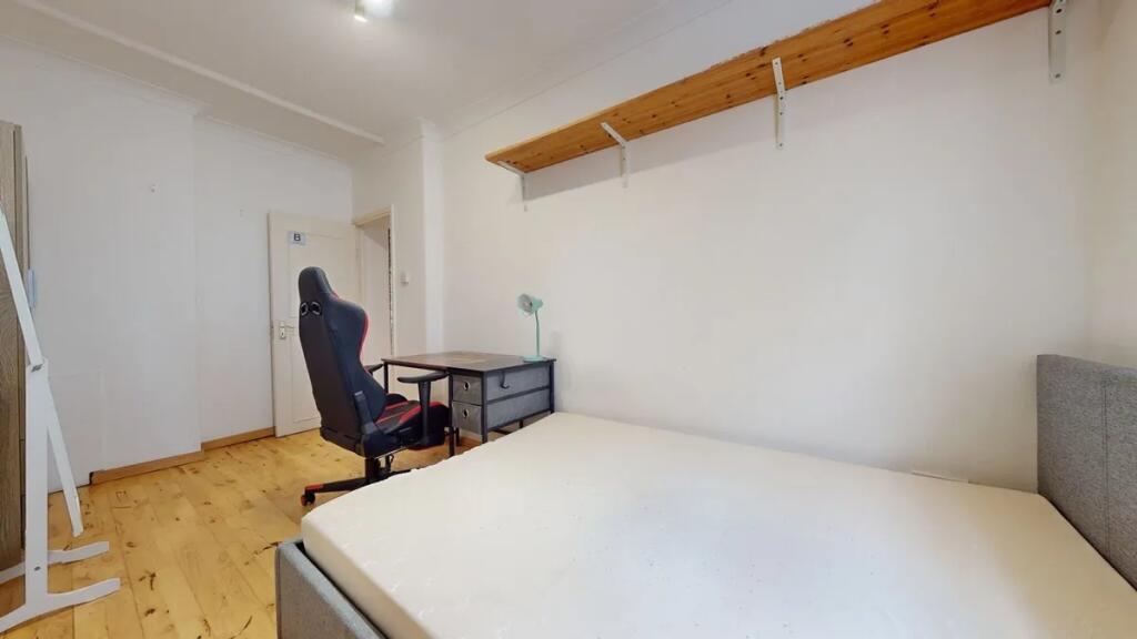 Bright and tidy double bedroom featuring wooden...