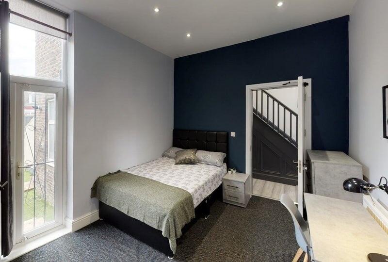 A neatly presented bedroom featuring a comforta...
