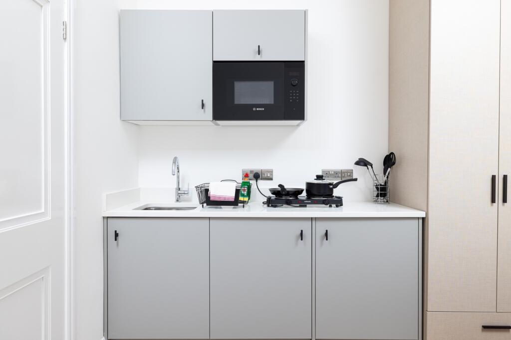 Modern kitchen featuring sleek cabinetry, essen...