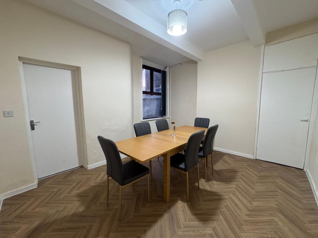 A neat, modern communal workspace featuring a w...