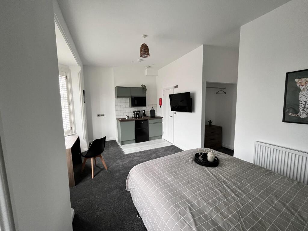 Spacious double bedroom featuring a cozy ambian...