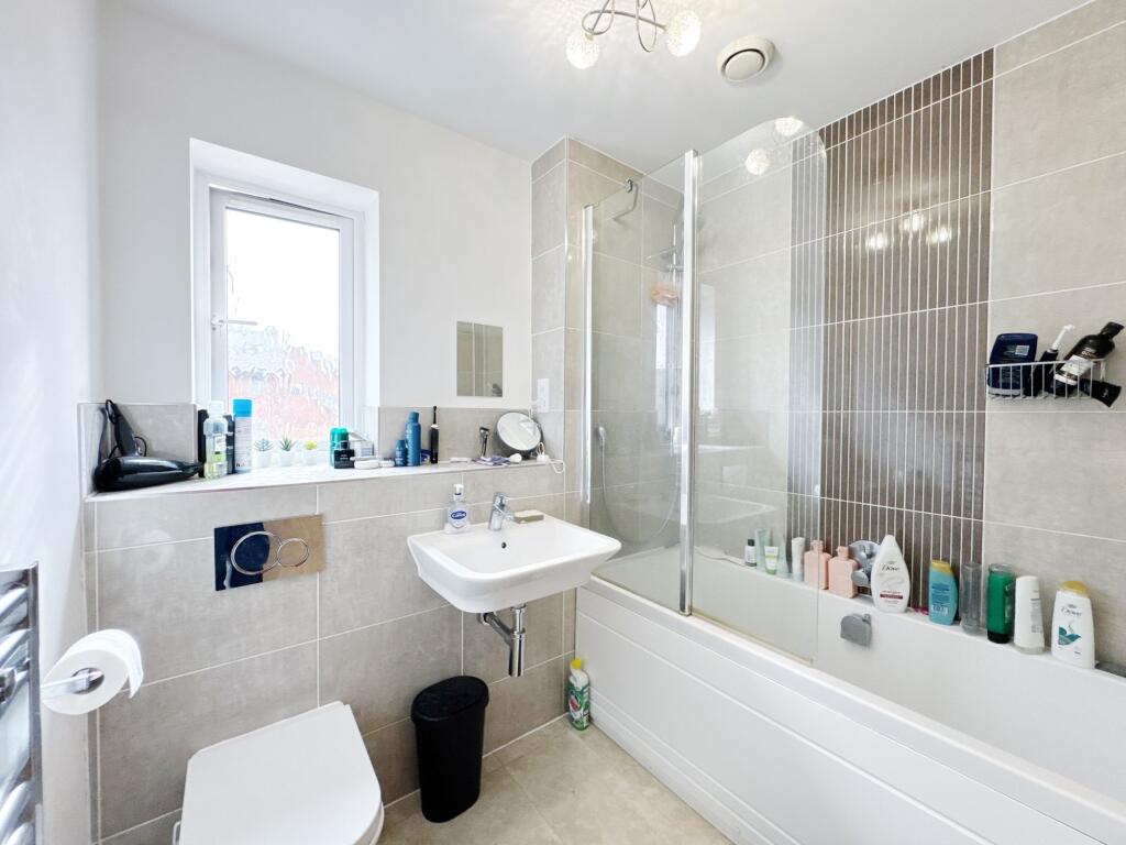 Bright and modern bathroom featuring a bathtub ...