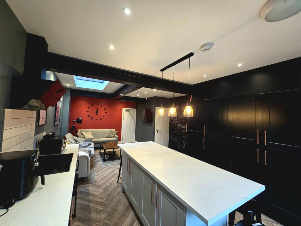 Modern and spacious kitchen featuring a large c...