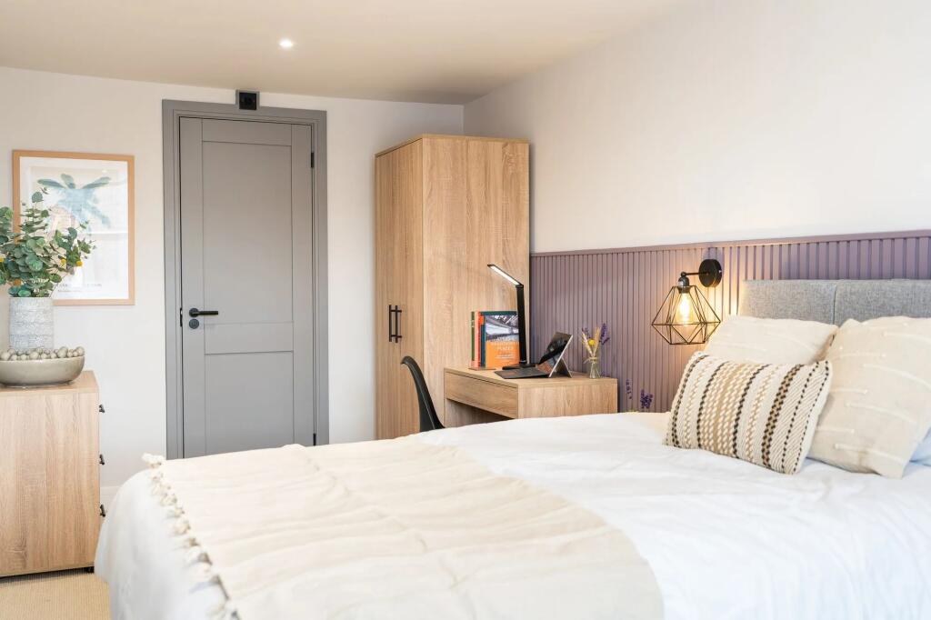 Bright, modern master bedroom with a comfortabl...