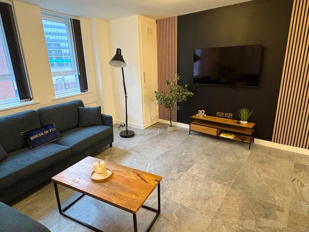 A modern living room featuring a dark green sof...