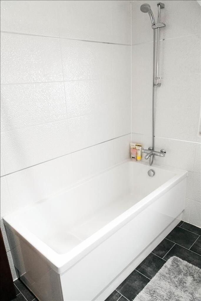 A modern bathroom featuring a sleek bathtub wit...