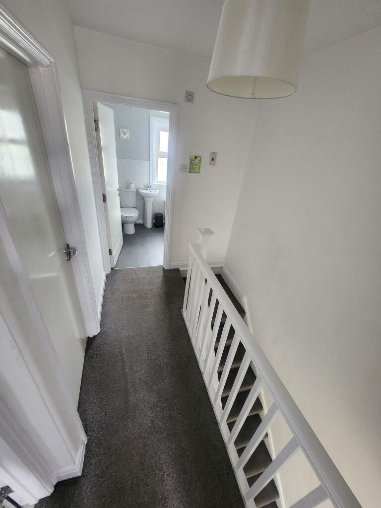 Bright and clean hallway with neutral decor and...