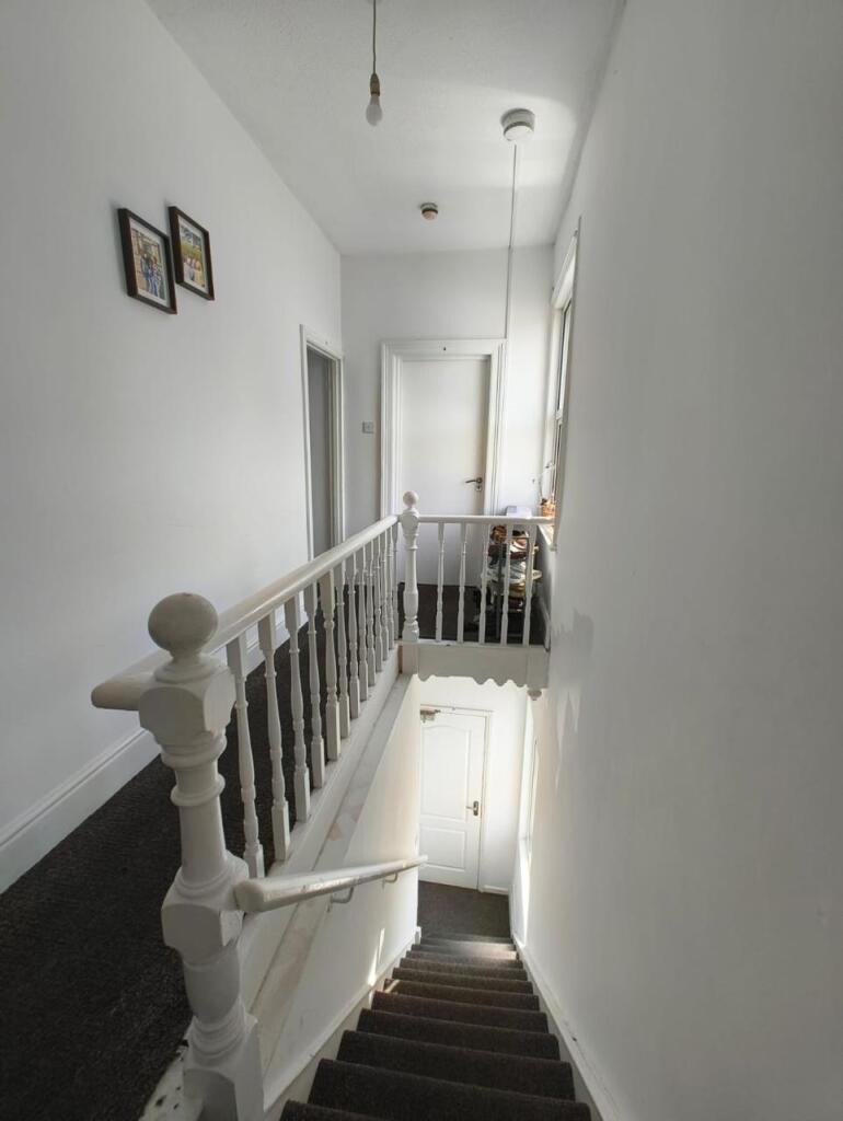 Bright and clean hallway with white walls and c...