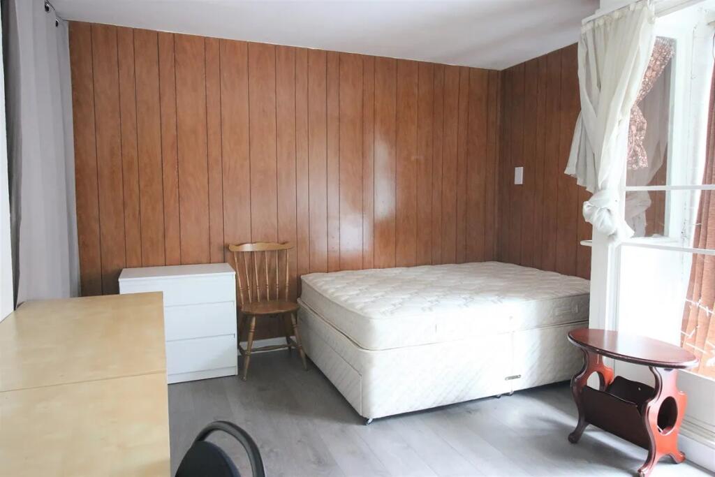 Bright double bedroom featuring a large window ...