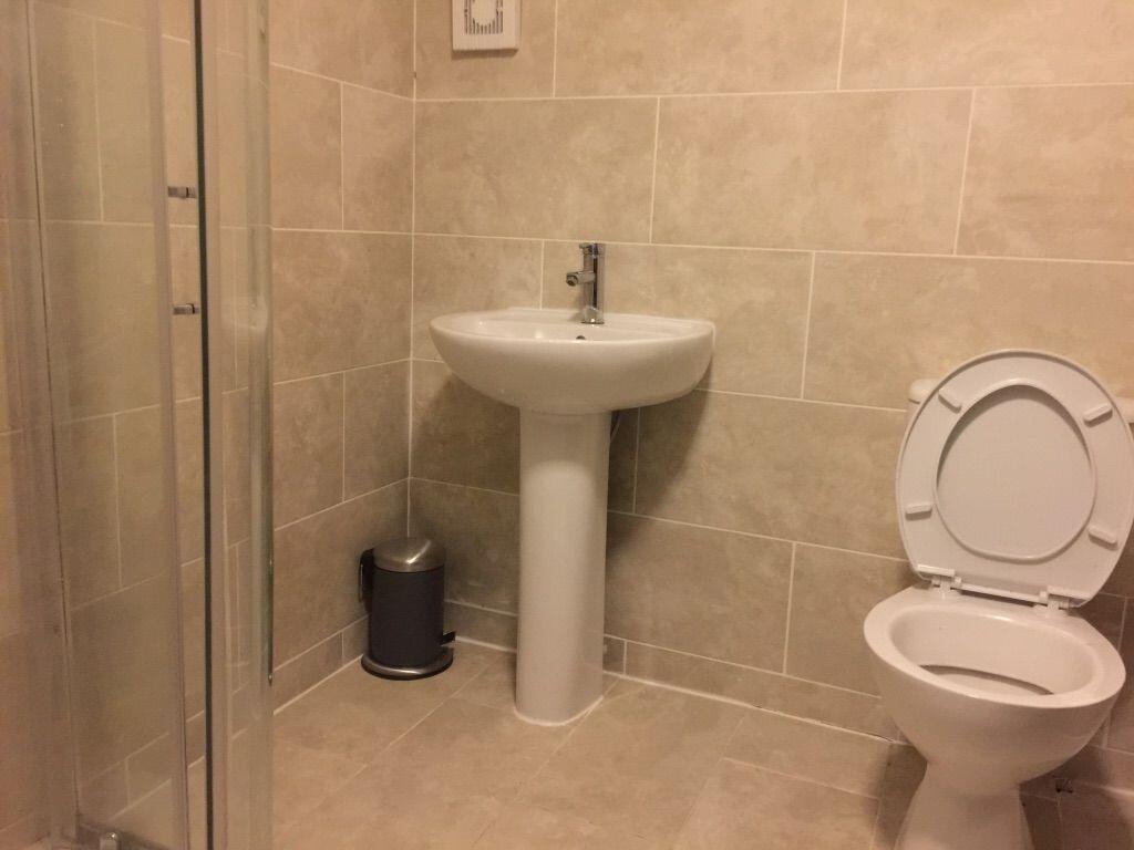 Clean, tiled bathroom with a pedestal sink, cor...