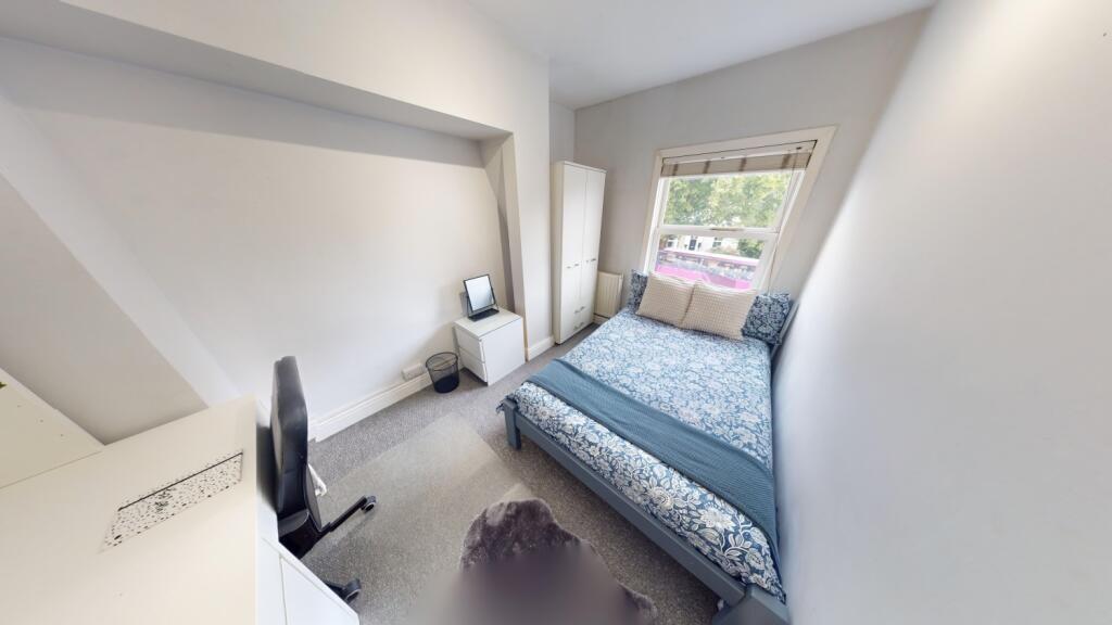 A bright and tidy double bedroom featuring a co...