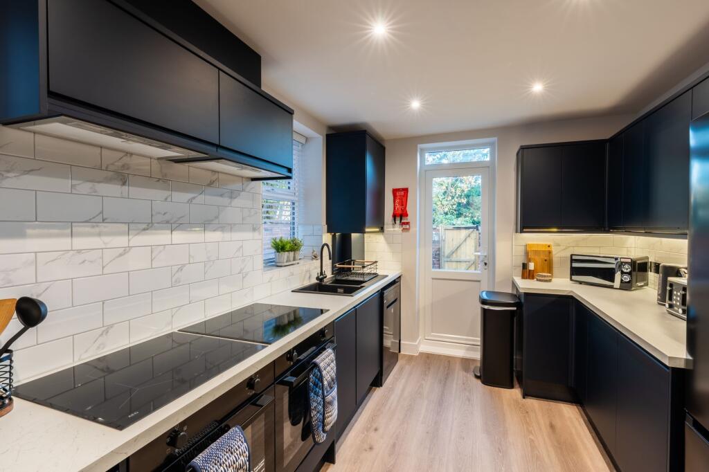 Bright modern kitchen with sleek dark cabinetry...