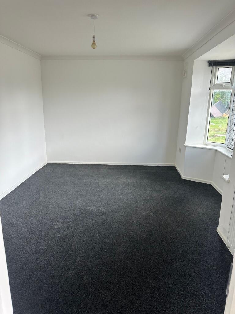 A clean and freshly carpeted double bedroom fea...