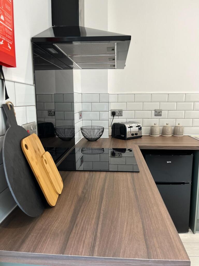 This modern kitchen features sleek countertops ...