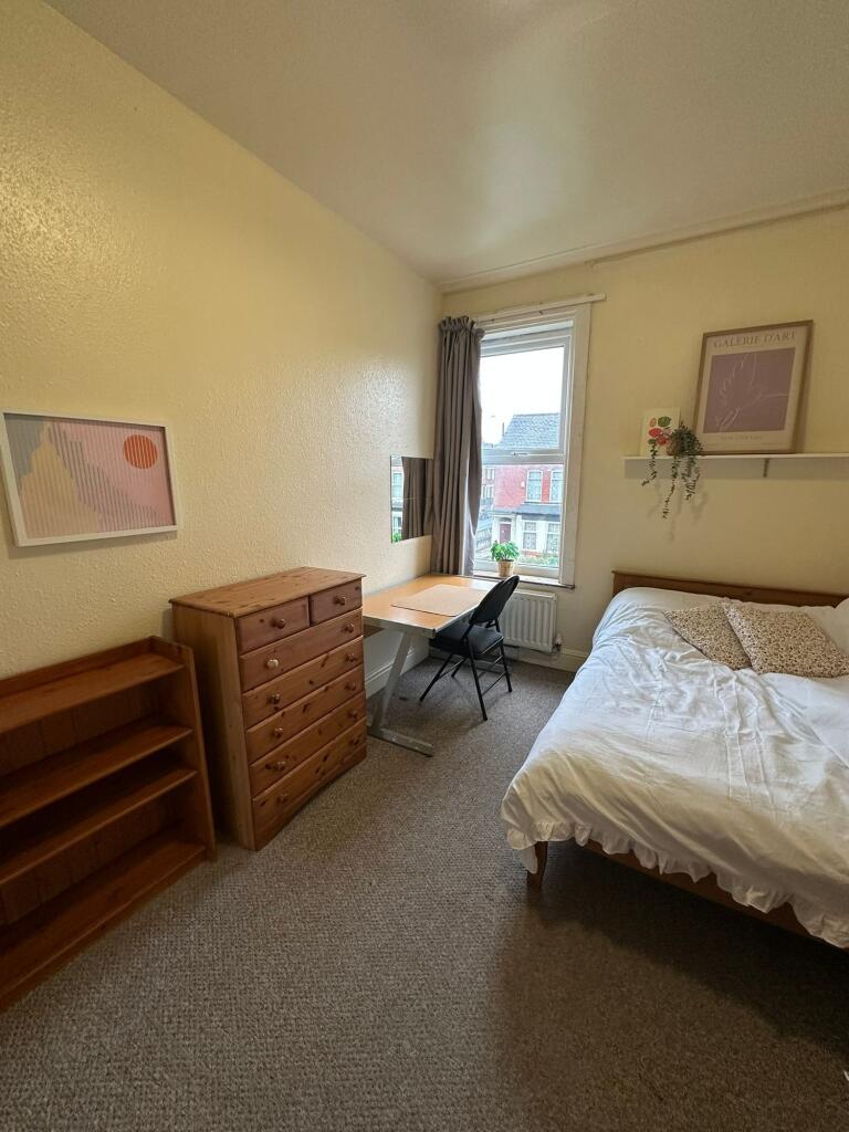 A cozy single bedroom featuring a comfortable b...