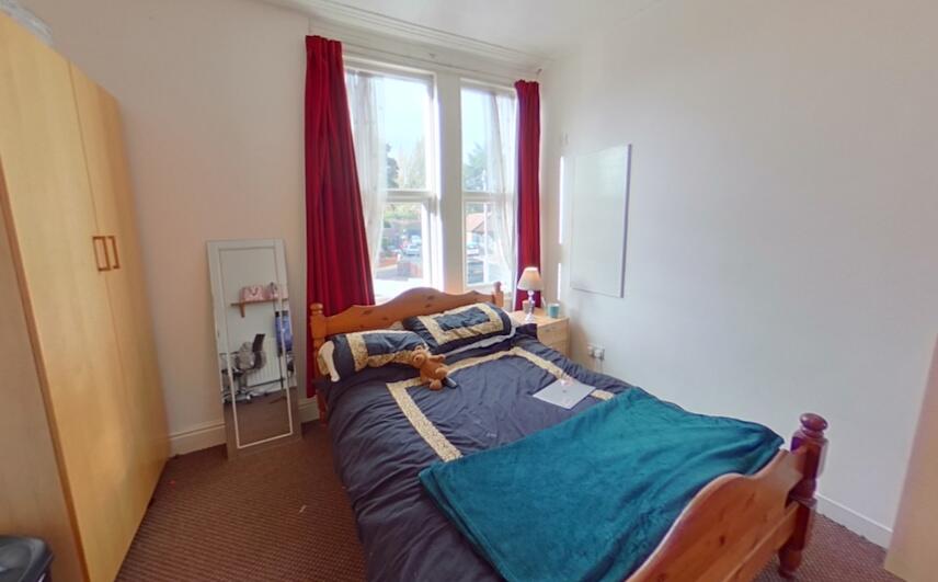 Cozy bedroom featuring a wooden single bed posi...
