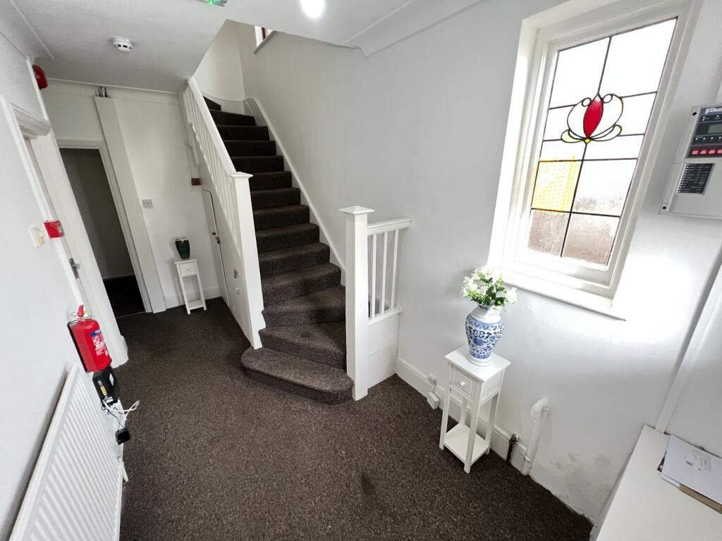 Bright hallway featuring a decorative stained g...