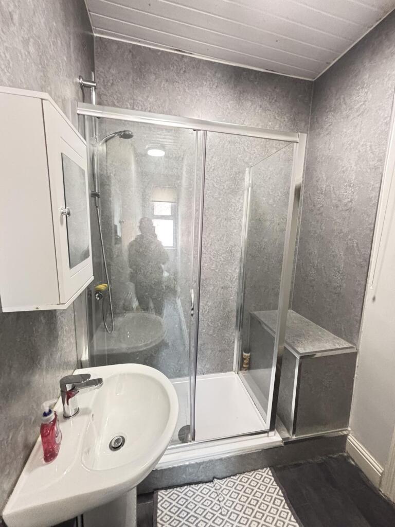A modern bathroom featuring a spacious shower c...