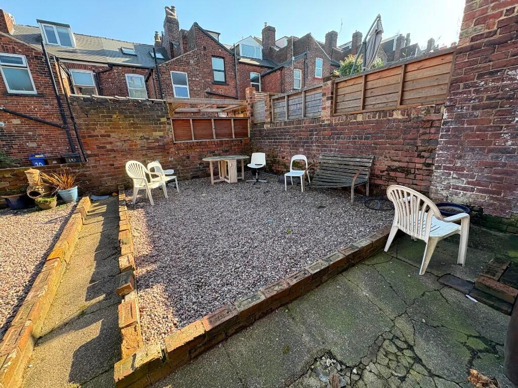A sunny, well-maintained garden with ample pave...