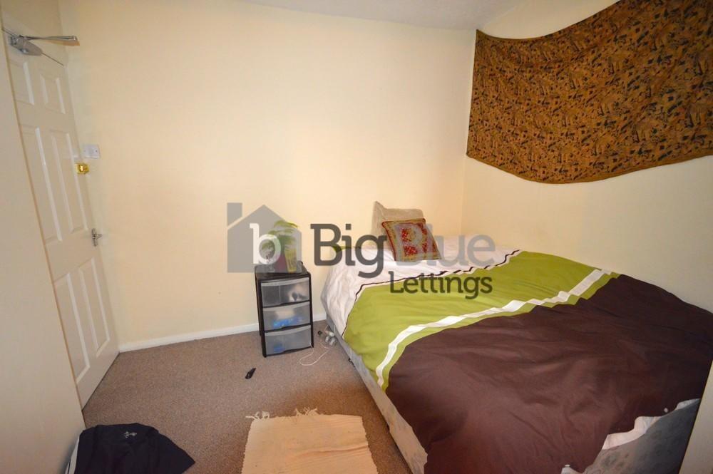 A cozy single bedroom featuring a neatly made b...